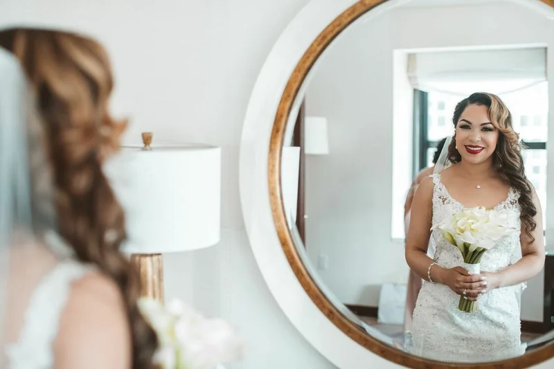 bride looking at her makeup in the mirror